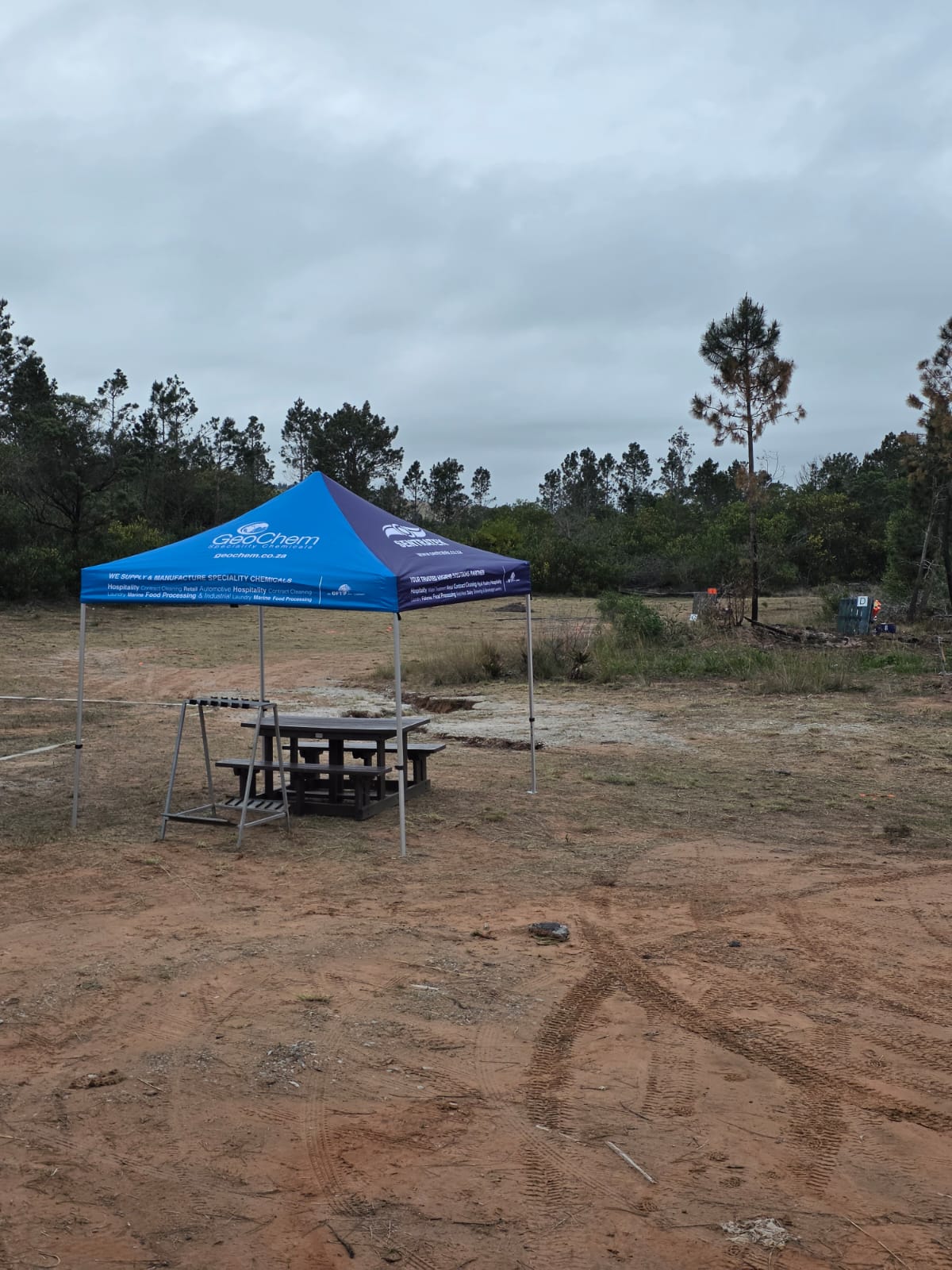 A sponsored gazebo with a picnic bench and gun rack on an outer sporting stand at PECTC