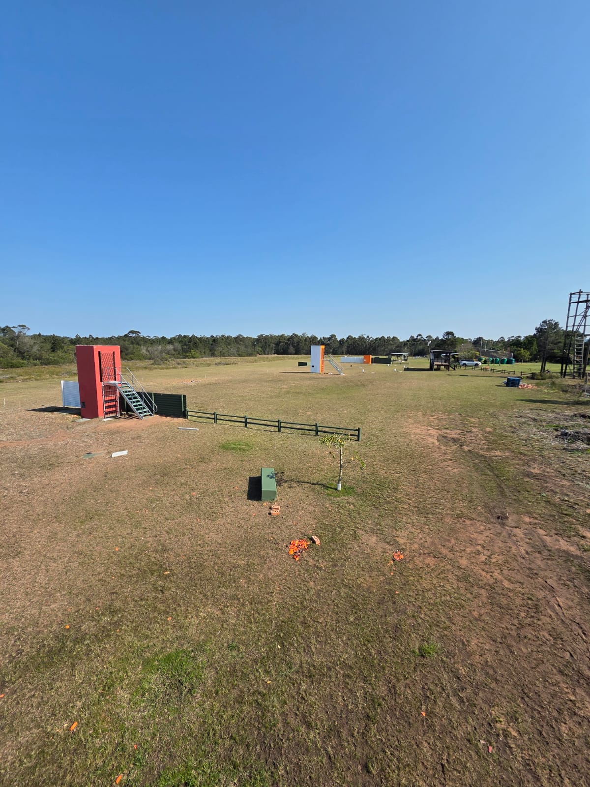 A red target tower with steps beside a green fence on the PECTC grass ranges
