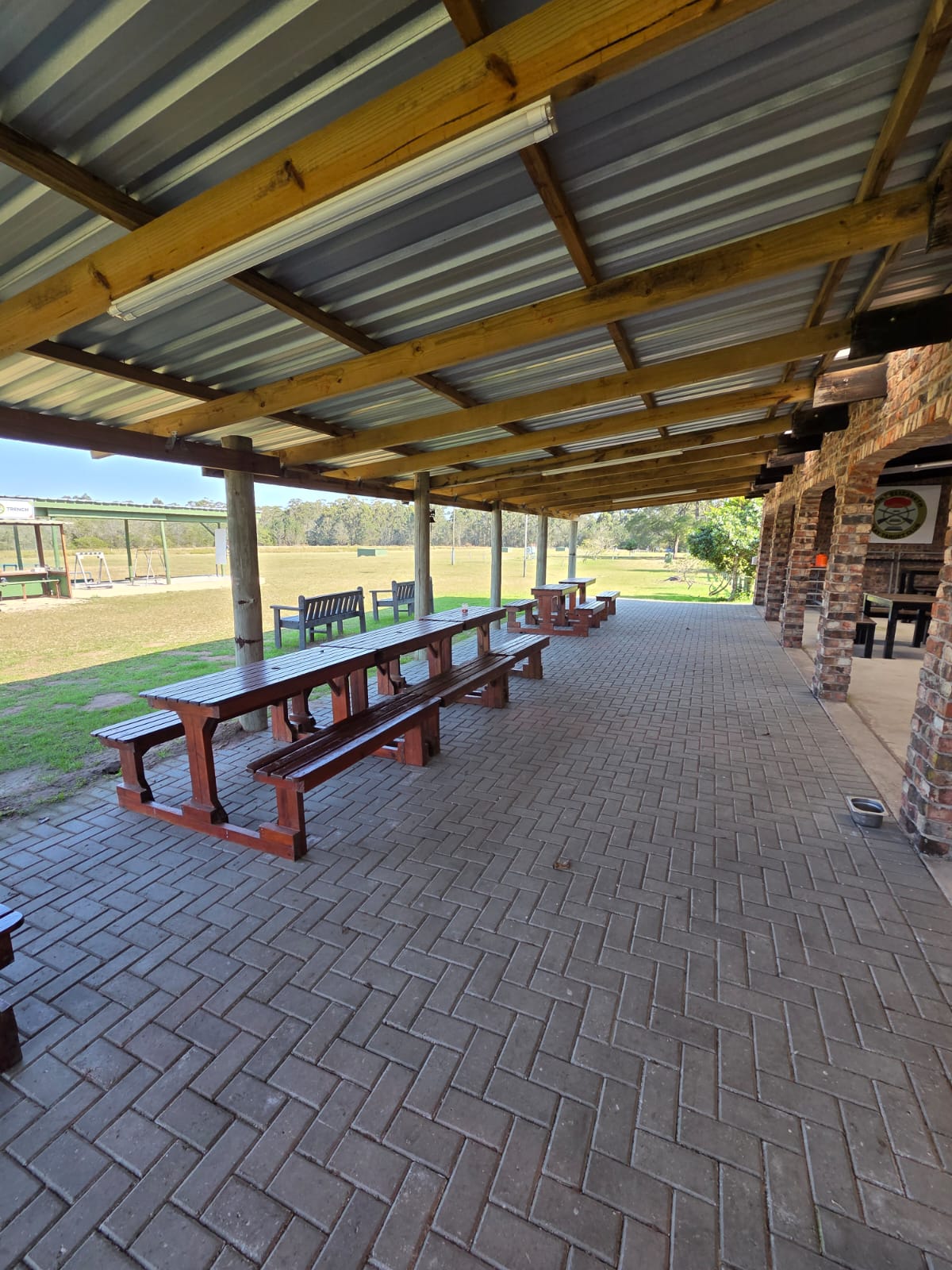 Paved veranda with wooden picnic tables looking out over the PECTC ranges
