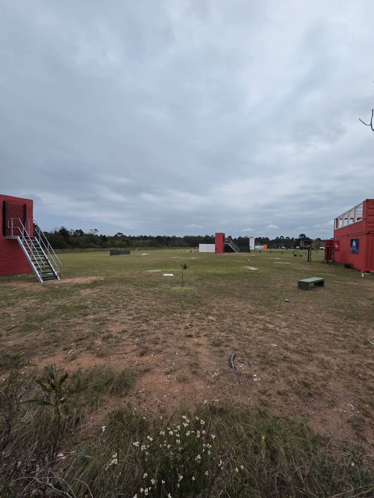 The open PECTC range under a cloudy sky with red shooting structures on either side and target towers in the distance